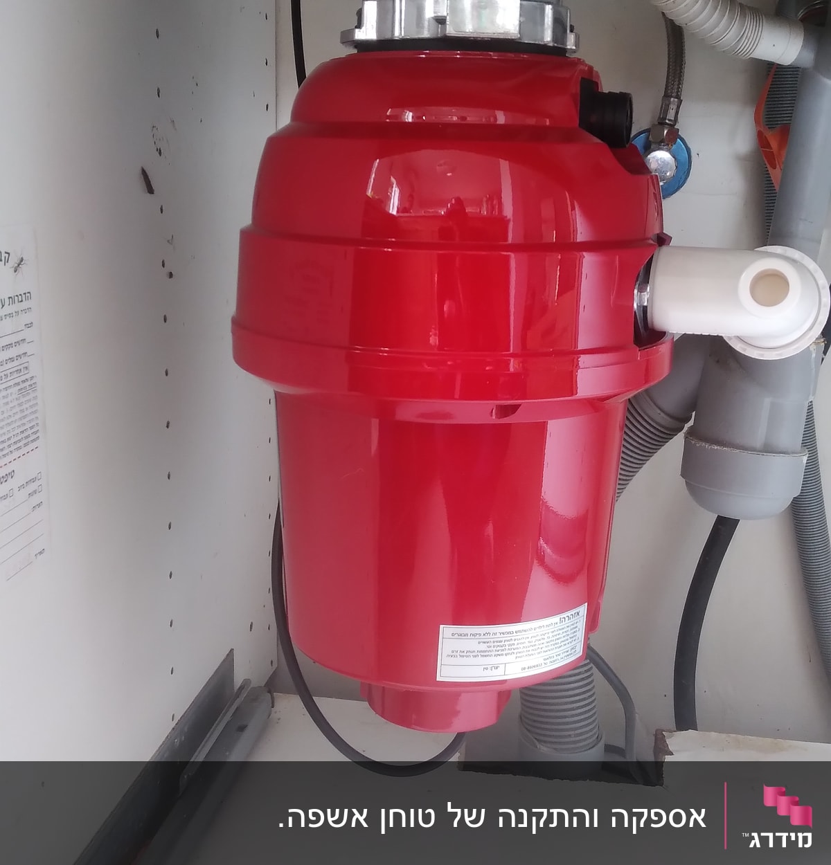 מכשיר אדום מתחת לכיור עם צינורות חיבור